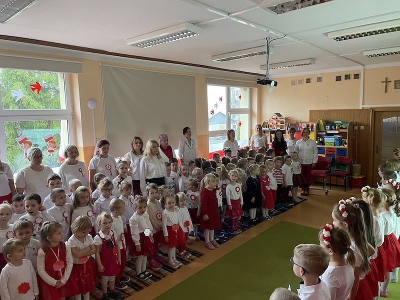 Dzieci i nauczycielki stoją na baczność.