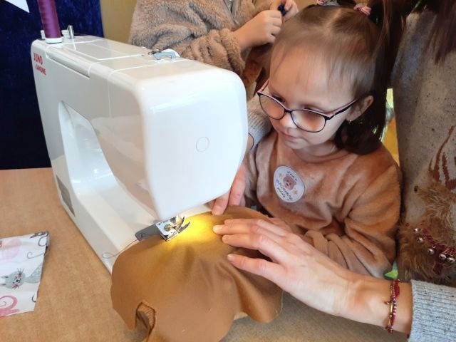 dziecko siedzi przy maszynie