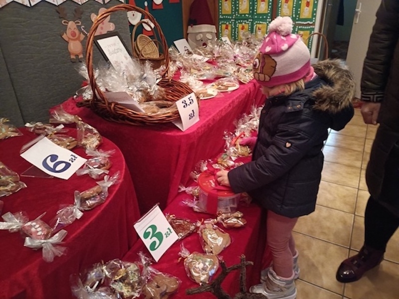 Przedszkolak z rodzicem wybiera produkt na kiermaszu