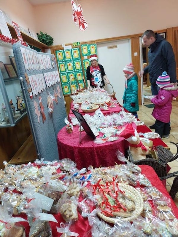 Przedszkolak z rodzicem wybiera produkt na kiermaszu