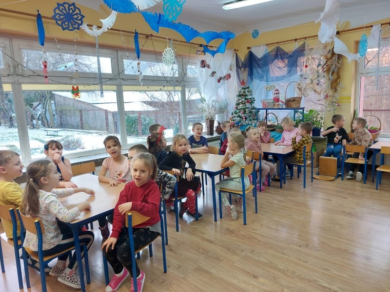 dzieci siedzą przy stolikacj