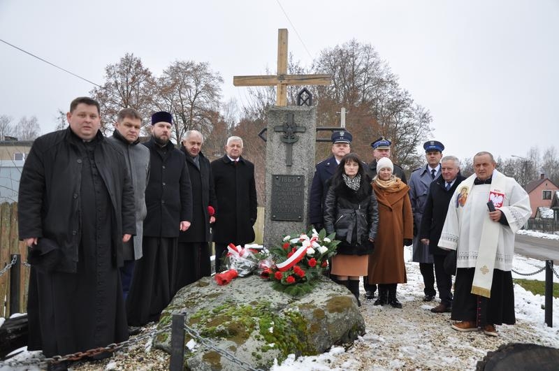 Grupa osób stoi przy pomniku w Orzeszkowie