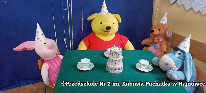 maskotki z bajki o Kubusiu Puchatku siedzą przy stoliku z filiżankami
