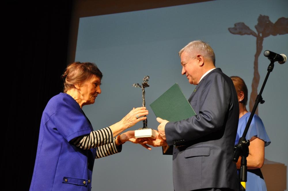 Kobieta i meżczyzna wręczają nagrodę lauratce