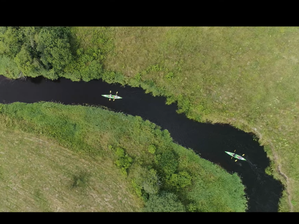 widok na rzekę z lotu taka. PO rzecy płyną dwa kajaki.