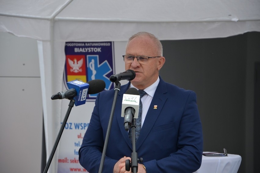 mężczyzna stoi przy mikrofonie.