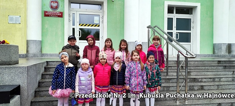 Dzieci pozują do zdjecia przed budynkiem Hajnowskiego Domu Kultury