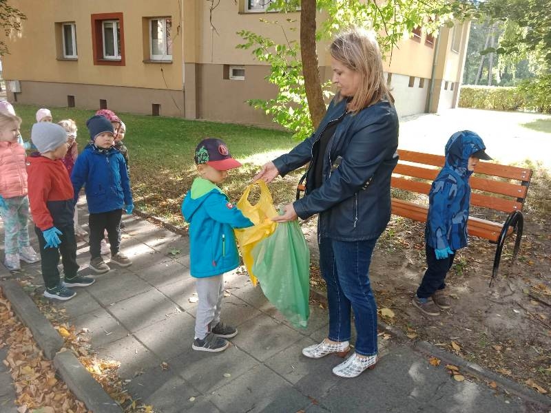 Dzieci wrzucają do worka śmieci
