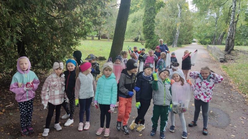 Dzieci zbierają w parku śmieci