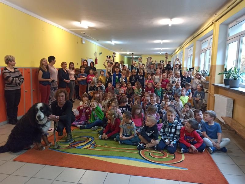 duża grupa dzieci i opiekunów oraz pies