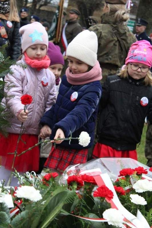 delegacja w składzie: Pani Dyrektor i wychowawczynie z grupy IX wraz z dziećmi: Olą, Malwiną, Hanią i Tatianą składającą, jedenastego listopada, kwiaty pod Pomnikiem ofiar i represji w skwerku dr. Wasilewskiego.
