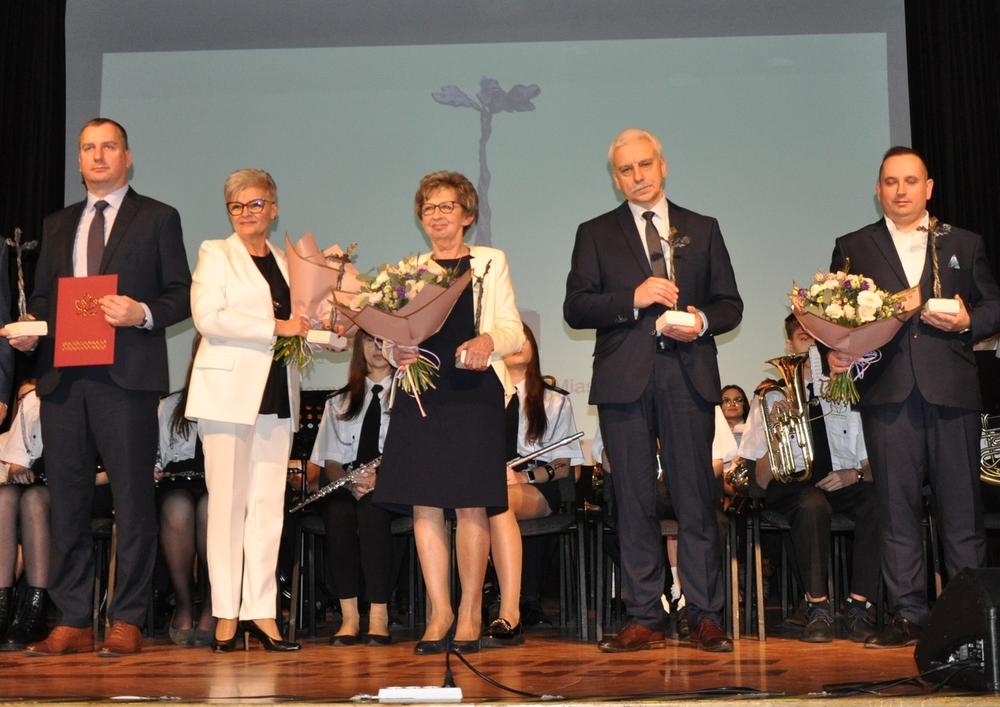 Laureaci ze statuetkami i kwiatami w dłoniach pozują do zdjęcia.