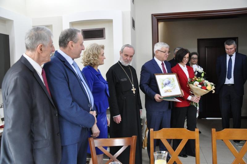 burmistrz pokazuje obraz, obok stoją pozostali goście