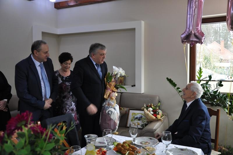 sekretarz gminy Dubicze Cerkiewne wręcza kwiaty i prezent