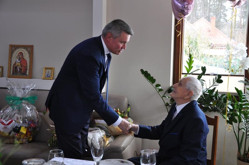 kierownik ZUS składa życzenia jubilatowi i wręcza upominek