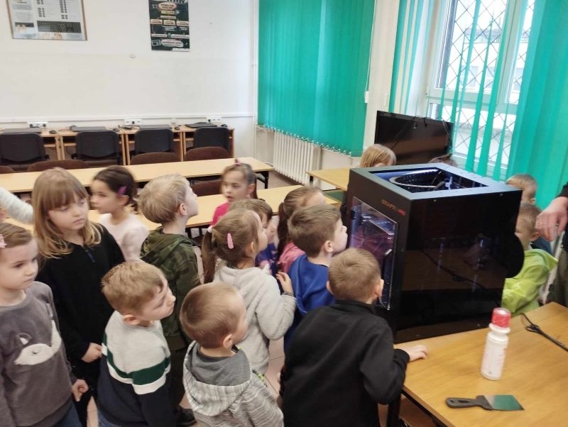 dzieci przyglądają sie pracy drukarki 3D