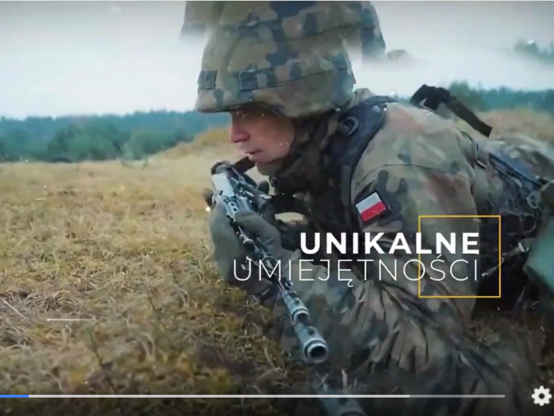 ujęcie ze spotku reklamowego przedstawiającego żołnierza leżącego na trawie