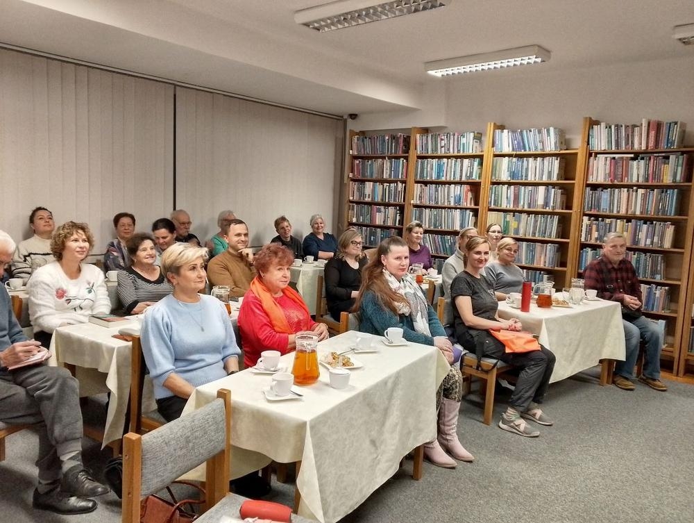 słuchacze na spotkaniu w sali bibliotecznej