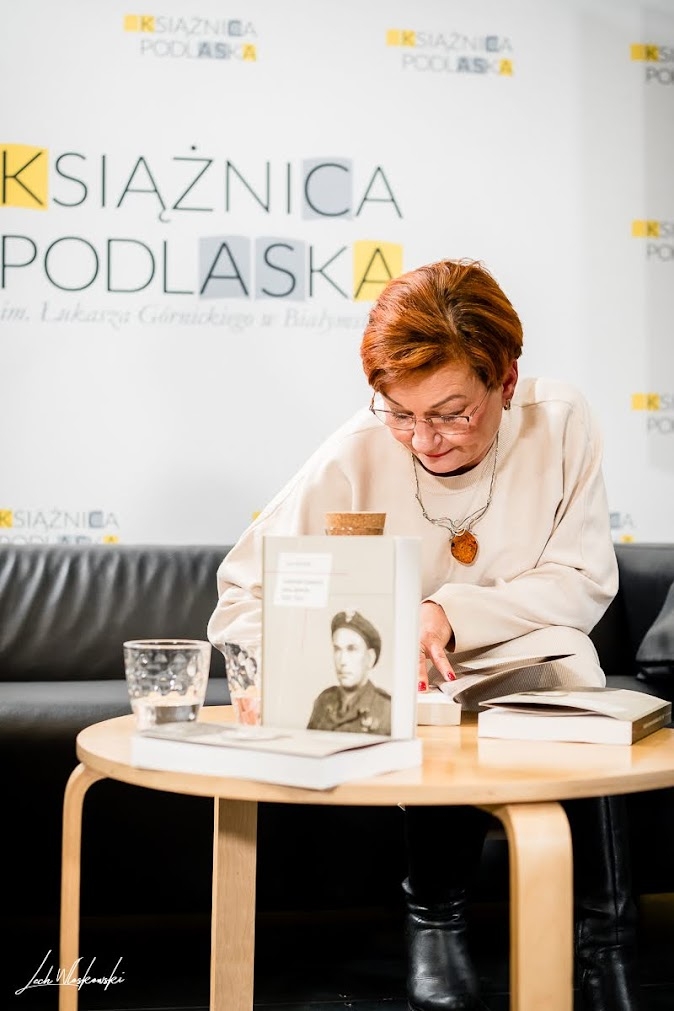 kobieta składa autograf na książce