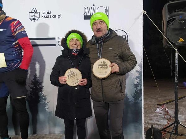 para na podium trzymają krążki z drewna - medale