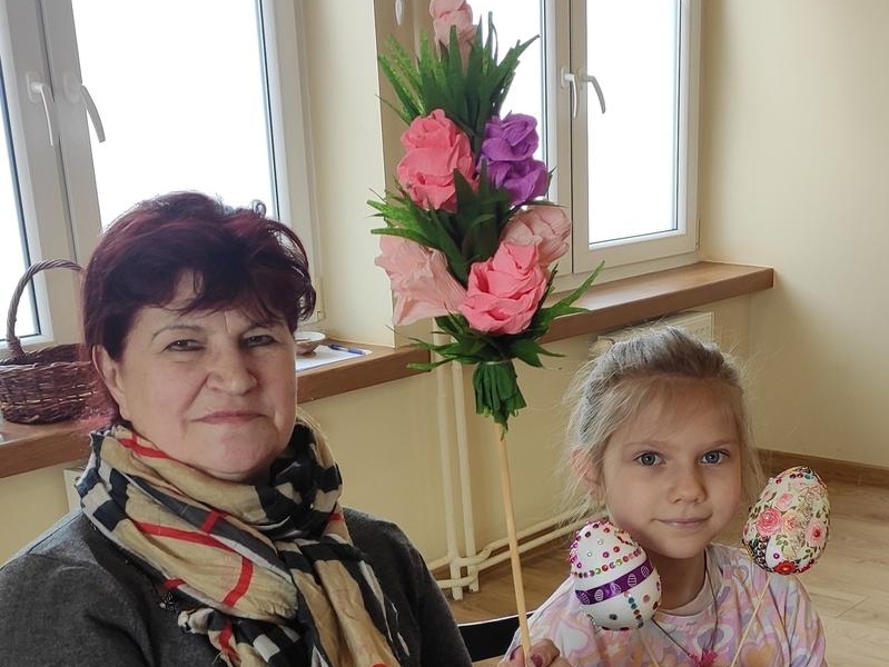 kobieta z dzieckiem prezenturją własnoręcznie zrobioną palmę i jajka
