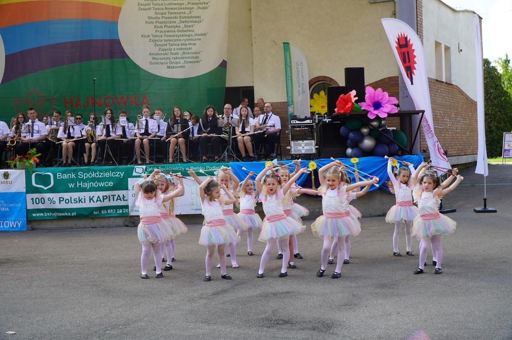 mażoretki tańczą na płycie amfiteatru, orkiestra gra na scenie