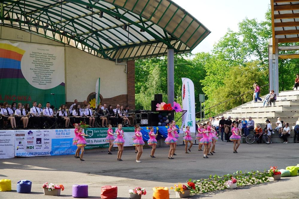 mażoretki tańczą na płycie amfiteatru, orkiestra gra na scenie