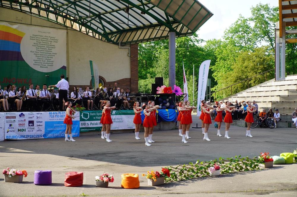 mażoretki tańczą na płycie amfiteatru, orkiestra gra na scenie