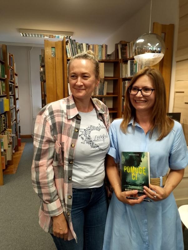 dwie kobiety. jedna trzyma książkę