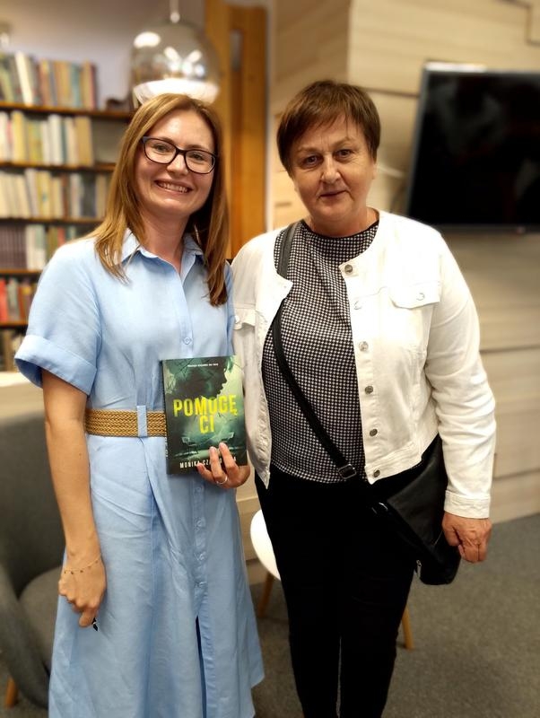 dwie kobiety. jedna trzyma książkę