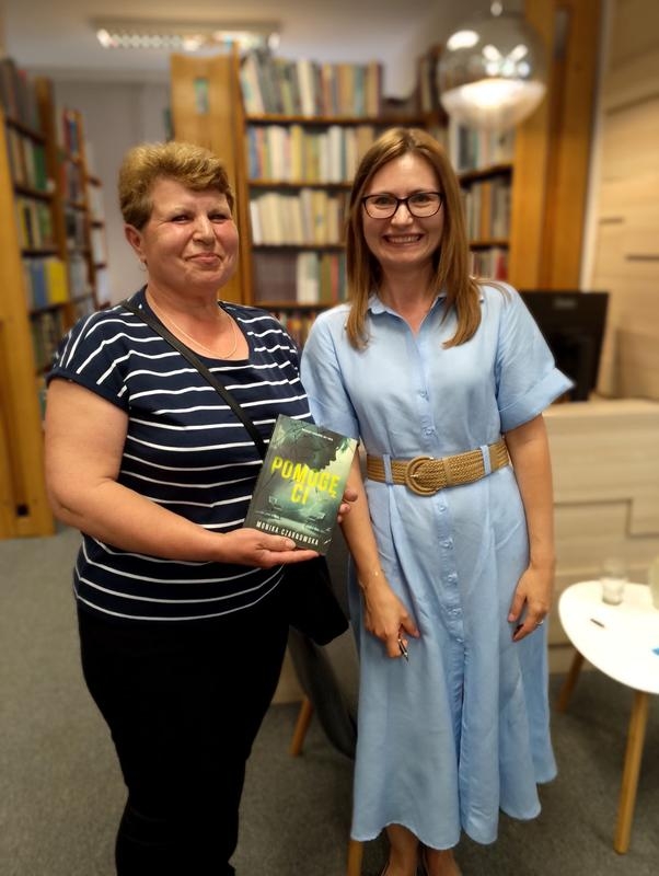 dwie kobiety. jedna trzyma książkę