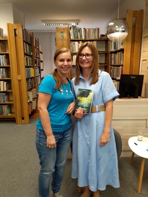 dwie kobiety. jedna trzyma książkę