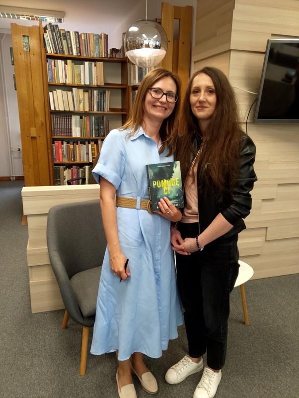 dwie kobiety. jedna trzyma książkę