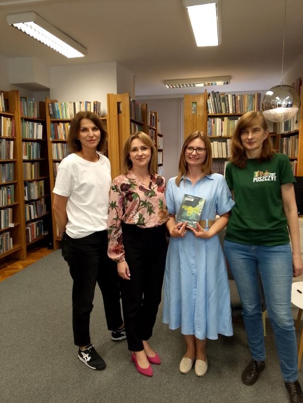 cztery kobiety pozują do zdjęcia. jedna trzyma książkę