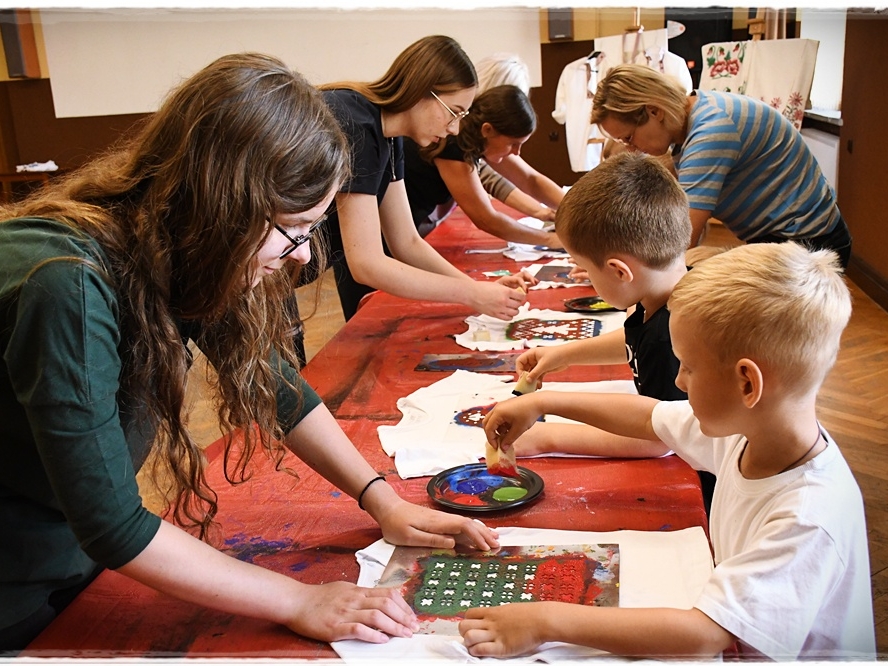 instruktorki pomagają dzieciom przy malowaniu koszulek