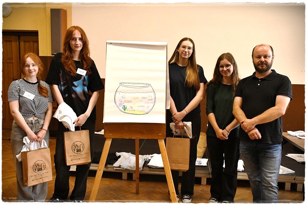 strektoremstydentki i dyrektor muzeum pozują do zdjęcia przy pracy plastycznej prezentowanej na sztalugach