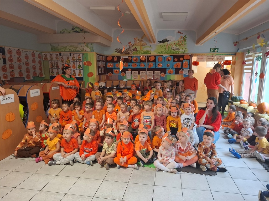 duża grupa dizeci w pomarańczowych storjach pozuje do zdjęcia