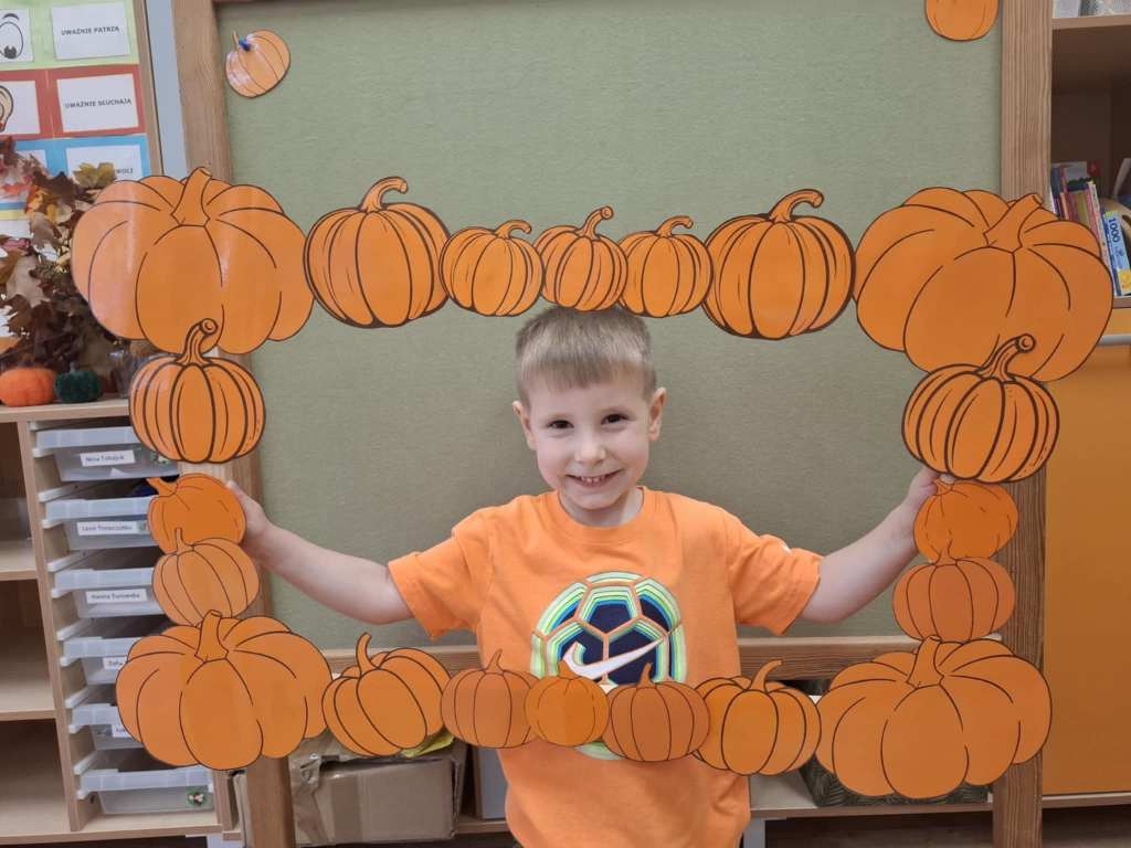 dzieci pozujące w dyniowej ramce