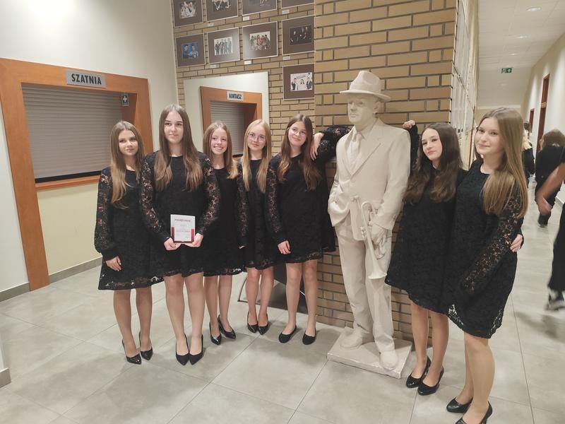 zespół pozuje do zdjęcia przy figurze