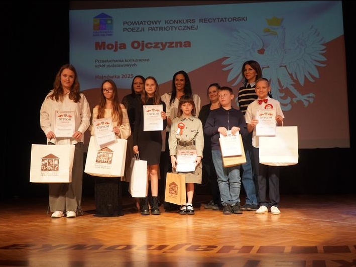 uczestnicy konkursu z dyplomami i nagrodami stoją na scenie. w tle scenografia okolicznościowa