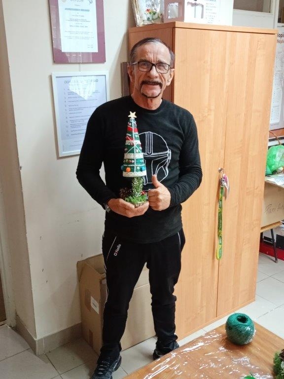Mężczyzna prezentuje wykonaną choinkę