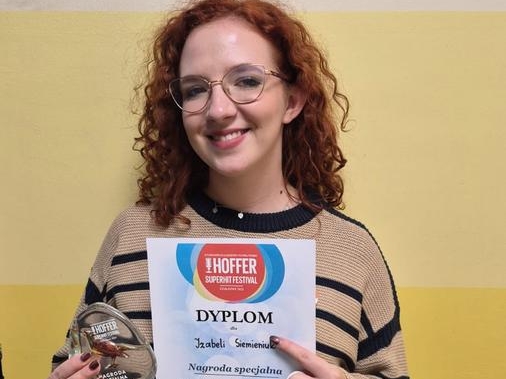 kobieta ze statuetką i dyplomem