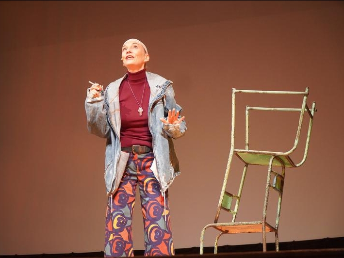 aktorka na scenie HDK. obok stoją metalowe krzesła