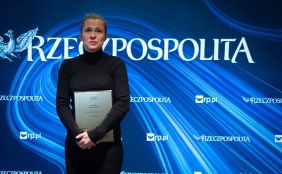 kobieta z dyplomem. W tle widać napis RZECZPOSPOLITA