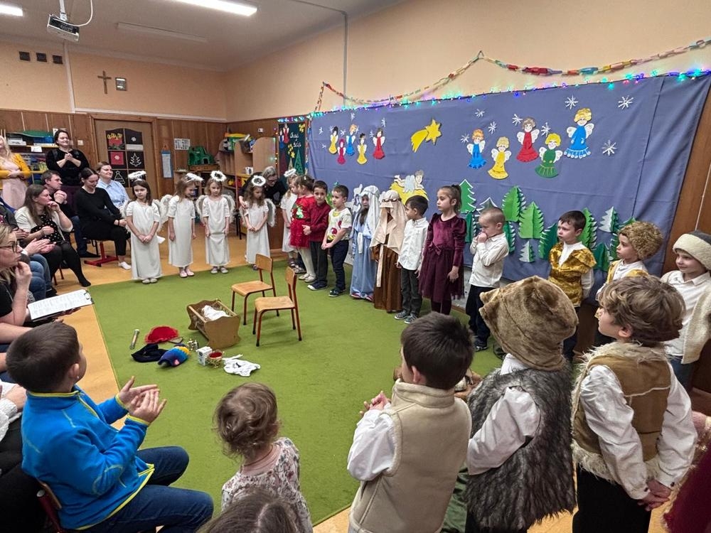 jasełka bożonarodzeniowe w wykonaniu grupy piątej na tle bożonarodzeniowej dekoracji