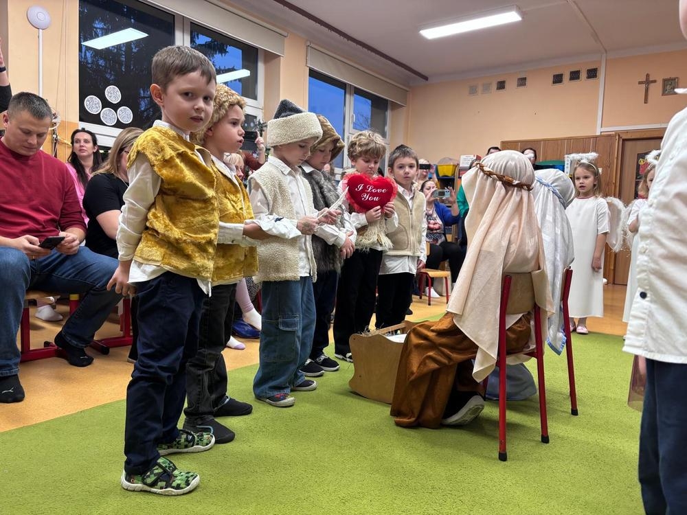 jasełka bożonarodzeniowe w wykonaniu grupy piątej na tle bożonarodzeniowej dekoracji