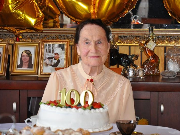 Maria Michalak przy torcie ze świeczkami 100
