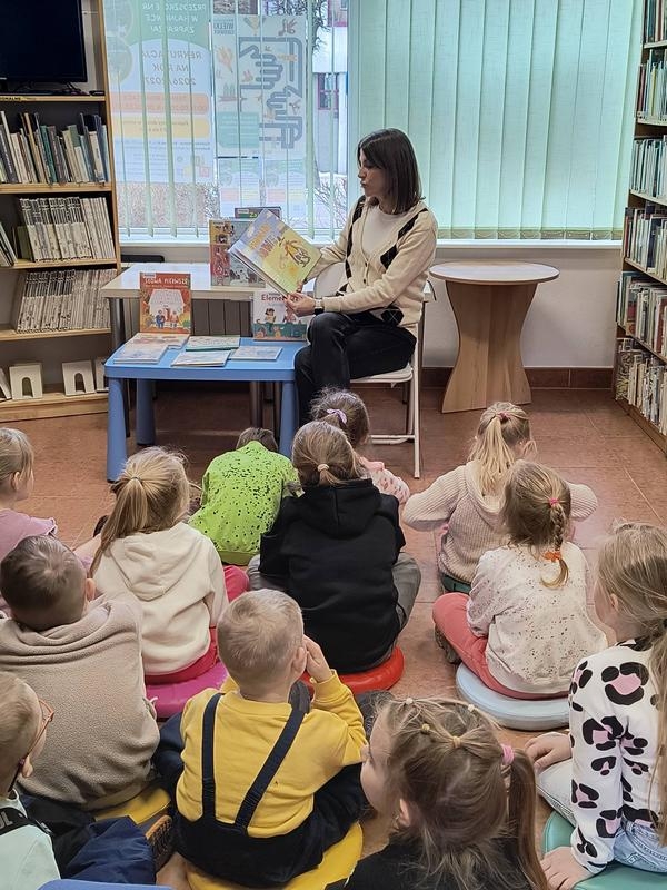 kobieta czyta dzieciom książkę