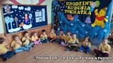 Zdjęcie ukazuje zabawy muzyczne, ruchowe i z chustą animacyjną. Fotografie dzieci z grupy Puchatki pokazują dzieci w żółtych koszulkach siedzące wspólnie z nauczycielkami przebranymi za Kubusia Puchatka, Kłapouchego i Tygryska.