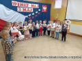 Dzieci z grupy IV Króliczki siedzące w kręgu z flagami biało - czerwonymi w dłoniach recytują wiersz "Katechizm polskiego dziecka".